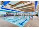 Indoor swimming pool with blue accents, skylights, and comfortable seating areas to relax poolside at 2343 Galilean Moon St, Henderson, NV 89044