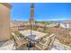 Relaxing balcony with seating, an umbrella, and views of the neighborhood and the city in the distance at 2496 Citrus Garden Cir, Henderson, NV 89052