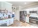 Modern kitchen with stainless appliances, white cabinetry, and a view to the living area at 2496 Citrus Garden Cir, Henderson, NV 89052