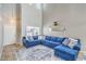 Bright living room boasts soaring ceilings, a large comfortable sofa, and neutral tile flooring at 2496 Citrus Garden Cir, Henderson, NV 89052