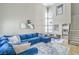 Bright living room boasts soaring ceilings, a large comfortable sofa, and neutral tile flooring at 2496 Citrus Garden Cir, Henderson, NV 89052