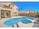 Inviting pool and spa in a private backyard with ample seating, with views of the home's exterior at 2496 Citrus Garden Cir, Henderson, NV 89052
