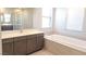 Bathroom with double sink vanity, soaking tub, walk-in shower and a large mirror at 2726 Marchetti Pl, Henderson, NV 89044