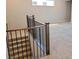 View of staircase with wooden banister and black iron spindles leading to a carpeted area at 2726 Marchetti Pl, Henderson, NV 89044