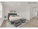 Bedroom with a tufted headboard bed, gray ottomans, and a neutral color palette at 334 Laurel Peak Dr, Henderson, NV 89015