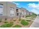 Contemporary townhouse with stone accents, a small garden, and a well-maintained lawn at 334 Laurel Peak Dr, Henderson, NV 89015