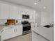 Modern white kitchen featuring stainless steel appliances and grey countertops at 334 Laurel Peak Dr, Henderson, NV 89015