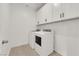 Well-lit laundry room features a washer, dryer, and white cabinetry for ample storage space at 334 Laurel Peak Dr, Henderson, NV 89015