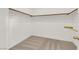 Empty walk-in closet with carpeted floor and wooden hanging rods, awaiting customization at 334 Laurel Peak Dr, Henderson, NV 89015