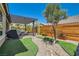 Well-manicured backyard with artificial turf, a pergola-covered patio, and a sleek outdoor kitchen area at 3434 Boleo Ct, Las Vegas, NV 89141