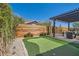 Entertaining backyard features artificial turf, a putting green, and a cozy pergola-covered patio at 3434 Boleo Ct, Las Vegas, NV 89141