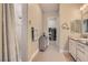 Neutral bathroom features a tiled shower, dual sinks, and doorway to a walk-in closet at 3434 Boleo Ct, Las Vegas, NV 89141