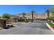 Gated community entrance with mature landscaping, palm trees, and desert views at 3434 Boleo Ct, Las Vegas, NV 89141