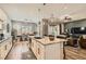Open kitchen features an island with seating, pendant lighting, and a seamless flow into the dining and living areas at 3434 Boleo Ct, Las Vegas, NV 89141