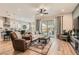 Open-concept living room with wood floors, a ceiling fan, and a sliding glass door to the backyard at 3434 Boleo Ct, Las Vegas, NV 89141