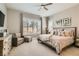 Comfortable bedroom featuring a ceiling fan, neutral decor, plantation shutters, and a sitting area at 3434 Boleo Ct, Las Vegas, NV 89141