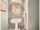 Charming powder room featuring a pedestal sink, decorative mirror, and textured walls at 3434 Boleo Ct, Las Vegas, NV 89141