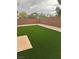 Spacious backyard with artificial grass, rock landscaping, and a brick privacy fence at 3748 Autumn King Ave, Henderson, NV 89052