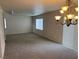 Bright, carpeted living room with large windows and a decorative chandelier at 3748 Autumn King Ave, Henderson, NV 89052