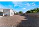 Expansive gravel backyard with block wall fencing and blue sky, perfect for customization and low maintenance at 3839 Dusty Glen Ct, North Las Vegas, NV 89032