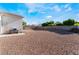 Rear yard with block wall perimeter, featuring an outdoor area for relaxing, and gravel across the entire backyard at 3839 Dusty Glen Ct, North Las Vegas, NV 89032