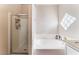 Bright bathroom featuring a tub and shower combination, enhanced by natural light from a glass block window at 3839 Dusty Glen Ct, North Las Vegas, NV 89032