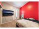 Cozy bedroom with a TV, neutral carpet, red accent wall, and curtains offering a comfortable private space at 3839 Dusty Glen Ct, North Las Vegas, NV 89032