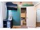 Bedroom with a TV, green accent wall, closet, and adjacent door leading out of the room at 3839 Dusty Glen Ct, North Las Vegas, NV 89032