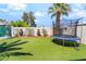 Backyard featuring well-maintained artificial grass, a trampoline, landscaping, and privacy fencing at 4406 Parkchester Cir, Las Vegas, NV 89108