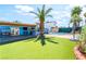A pool is surrounded by artificial grass and patio, and includes covered outdoor kitchen, for relaxation and entertainment at 4406 Parkchester Cir, Las Vegas, NV 89108