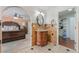 Bathroom with vanity and decorative mirror, connecting to bedroom through an arched entryway at 4406 Parkchester Cir, Las Vegas, NV 89108