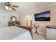 Comfortable bedroom boasts tile floors, a ceiling fan, and a mounted television for entertainment at 4406 Parkchester Cir, Las Vegas, NV 89108