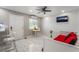 A bright guest room with a small dining area, a mounted television, tile floors and a cozy bed at 4406 Parkchester Cir, Las Vegas, NV 89108