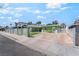 Green home with white horizontal slat fence, spacious driveway, and artificial grass at 4406 Parkchester Cir, Las Vegas, NV 89108