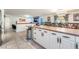 Open kitchen and dining room, with white cabinetry, stainless appliances, and tile floors at 4406 Parkchester Cir, Las Vegas, NV 89108