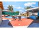A private backyard with a pool, two lounge chairs, and covered patio at 4406 Parkchester Cir, Las Vegas, NV 89108