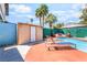 Backyard pool with lounge chairs, storage shed, palm trees, and privacy landscaping at 4406 Parkchester Cir, Las Vegas, NV 89108