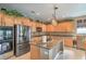 Kitchen featuring stainless appliances, wood cabinets, granite countertops, and an island with a sink at 4419 Via Bianca Ave, Las Vegas, NV 89141
