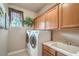 Bright laundry room featuring a washer, dryer, sink, and ample cabinet storage space at 4419 Via Bianca Ave, Las Vegas, NV 89141