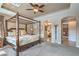 Large primary bedroom featuring a four poster bed, carpeted floors, and a tray ceiling with fan at 4419 Via Bianca Ave, Las Vegas, NV 89141