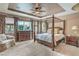 Primary bedroom with large windows, a tray ceiling, ceiling fan, and an elegant four poster bed at 4419 Via Bianca Ave, Las Vegas, NV 89141