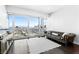 Bright living room features a leather sofa, sleek TV console, and expansive city views at 4471 Dean Martin Dr # 1502, Las Vegas, NV 89103