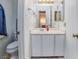 Bright bathroom with white vanity, toilet, and fixtures, next to hall with hardwood floors at 4614 Grand Dr # 1, Las Vegas, NV 89169