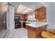 Functional kitchen with wooden cabinets, black appliances, a tiled floor, and a breakfast bar at 4614 Grand Dr # 1, Las Vegas, NV 89169