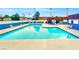 Large community pool surrounded by lounge chairs and palm trees on a bright, sunny day at 4614 Grand Dr # 1, Las Vegas, NV 89169