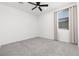A bright bedroom featuring a ceiling fan, neutral carpet, and natural light streaming through a window at 5136 Stonecrop St, North Las Vegas, NV 89031
