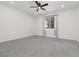 A bright bedroom featuring a ceiling fan, neutral carpet, and natural light streaming through a window at 5136 Stonecrop St, North Las Vegas, NV 89031