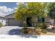 Charming single-story home showcasing lovely desert landscaping, a gray garage door, and a brick driveway at 5136 Stonecrop St, North Las Vegas, NV 89031