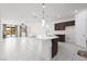 Bright kitchen and living space featuring a spacious island with quartz countertops and gray cabinets at 5136 Stonecrop St, North Las Vegas, NV 89031