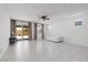 A spacious living room with tiled flooring, a modern ceiling fan, and a view of the backyard through sliding glass doors at 5136 Stonecrop St, North Las Vegas, NV 89031